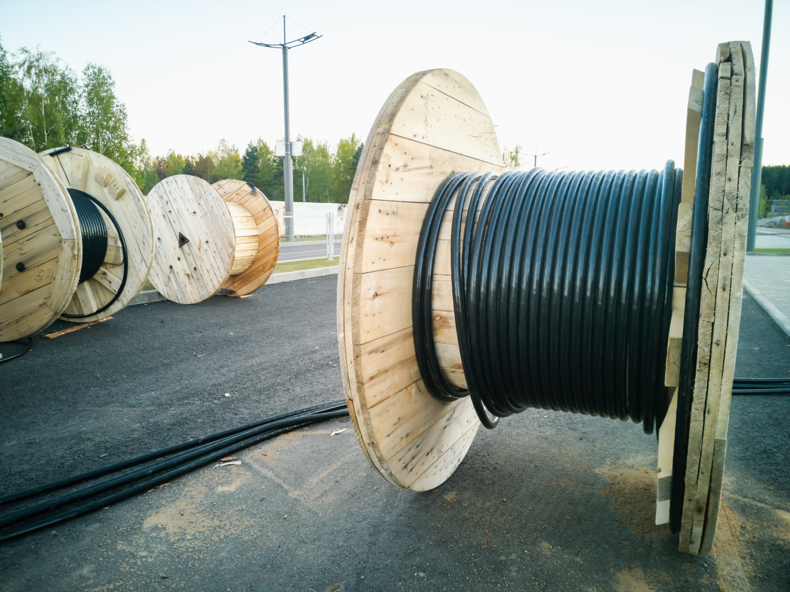 Wooden cable spools staged for installation at a project site